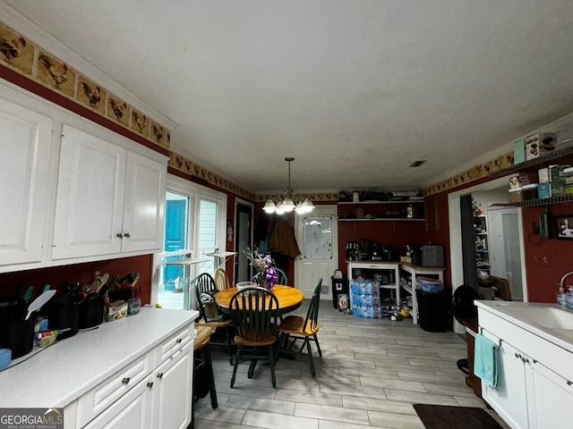 dining area with ornamental molding, sink, and an inviting chandelier