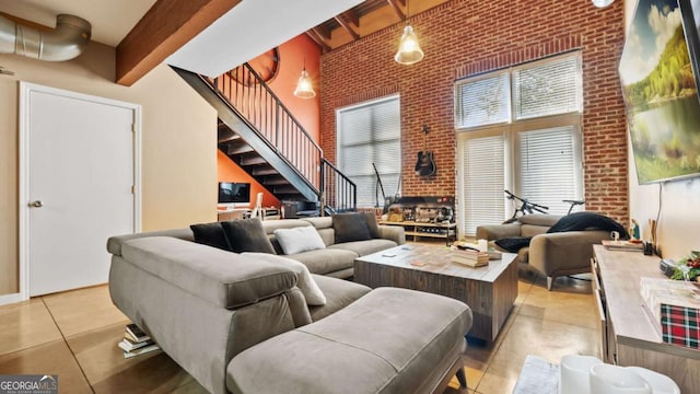 living room with beam ceiling, brick wall, and a high ceiling