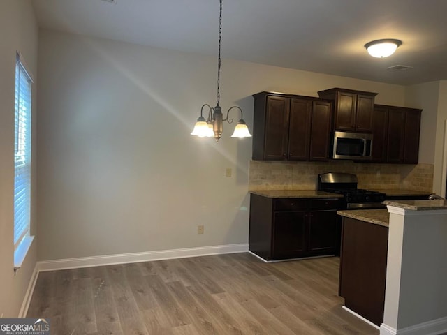 kitchen featuring hanging light fixtures, dark brown cabinets, black range with gas stovetop, and light hardwood / wood-style floors