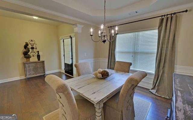 dining area featuring a tray ceiling, ornamental molding, and dark hardwood / wood-style floors