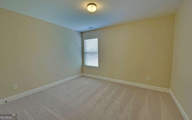 unfurnished room featuring light carpet