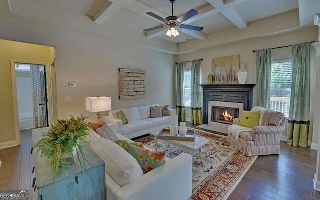 living room with dark hardwood / wood-style flooring, beam ceiling, plenty of natural light, and coffered ceiling