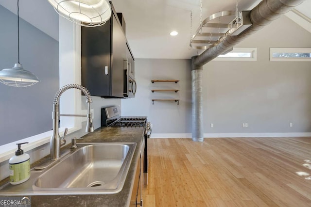 kitchen featuring sink, decorative light fixtures, light hardwood / wood-style flooring, and stainless steel appliances