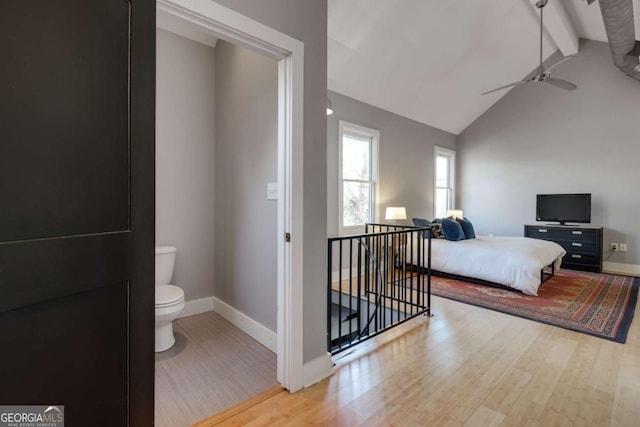 bedroom with ceiling fan, light hardwood / wood-style floors, and vaulted ceiling with beams