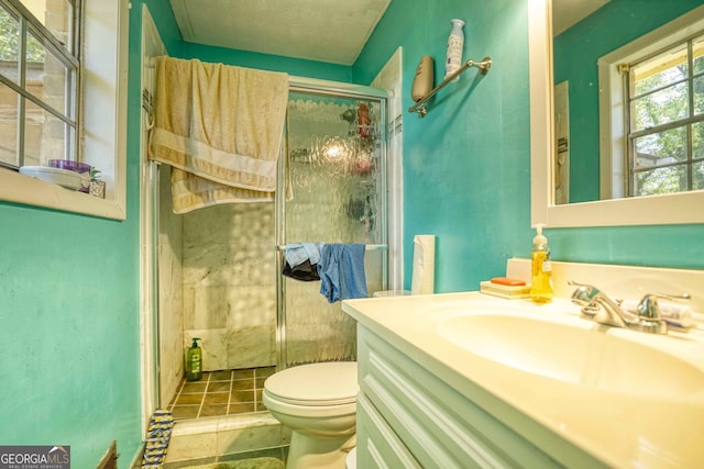 bathroom featuring vanity, tile patterned flooring, a shower with shower door, and toilet