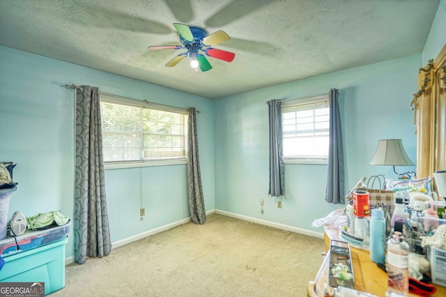 interior space featuring ceiling fan, light carpet, and a textured ceiling