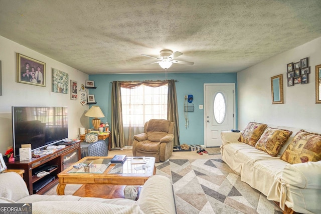 living room featuring ceiling fan, carpet, and a textured ceiling