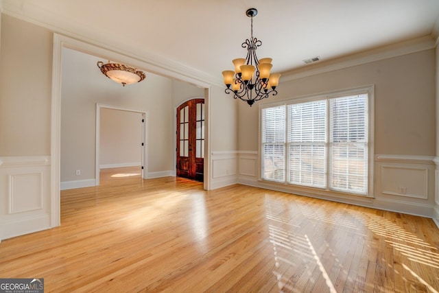 interior space featuring crown molding, wood-type flooring, and a chandelier