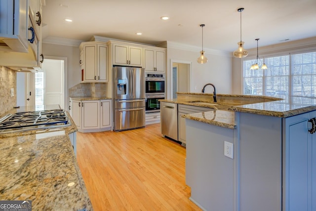 kitchen featuring sink, a kitchen island with sink, backsplash, hanging light fixtures, and stainless steel appliances