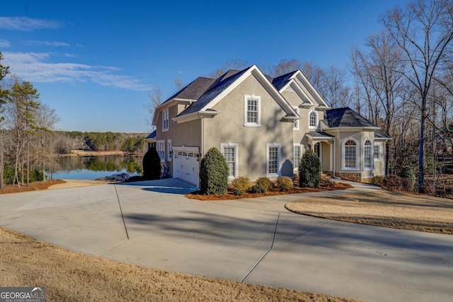 view of front of property with a garage and a water view