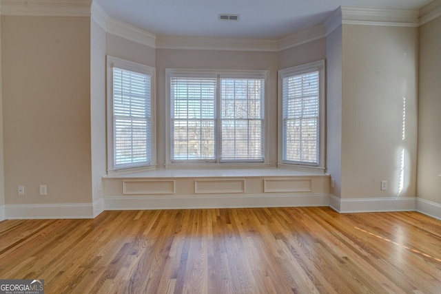 unfurnished room featuring ornamental molding and light hardwood / wood-style floors