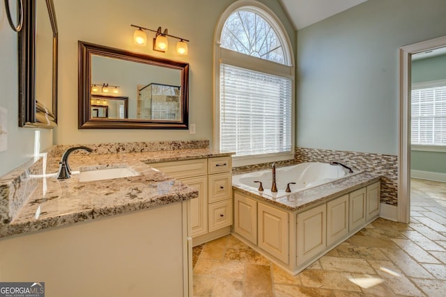 bathroom featuring lofted ceiling, vanity, and a washtub