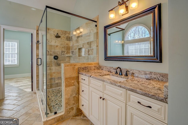 bathroom featuring vanity, a wealth of natural light, and a shower with door