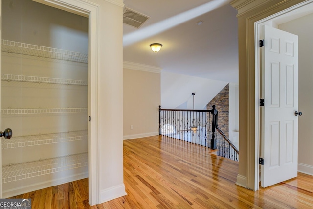 hallway with crown molding and hardwood / wood-style flooring