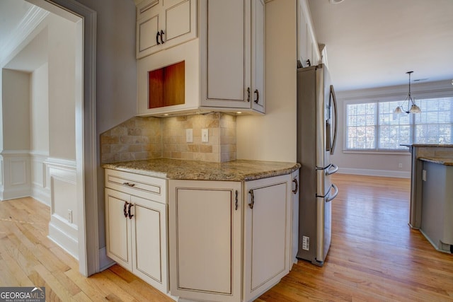 kitchen featuring cream cabinets, light hardwood / wood-style floors, decorative backsplash, stainless steel fridge with ice dispenser, and decorative light fixtures