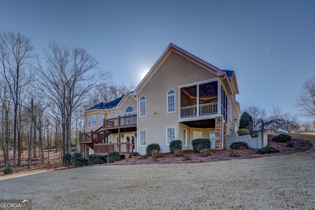 exterior space featuring ceiling fan, a deck, and a front lawn