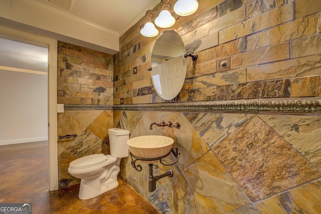 bathroom with ornamental molding, sink, concrete floors, and toilet