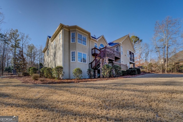 view of side of property with a yard and a deck