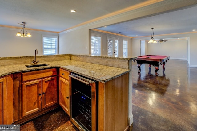 kitchen featuring crown molding, sink, beverage cooler, and decorative light fixtures