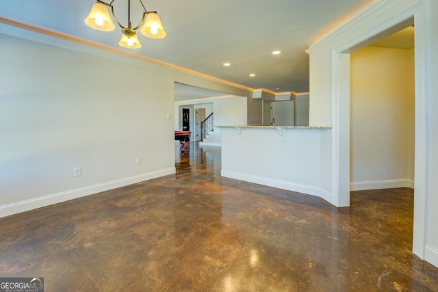 unfurnished living room with ornamental molding and a notable chandelier