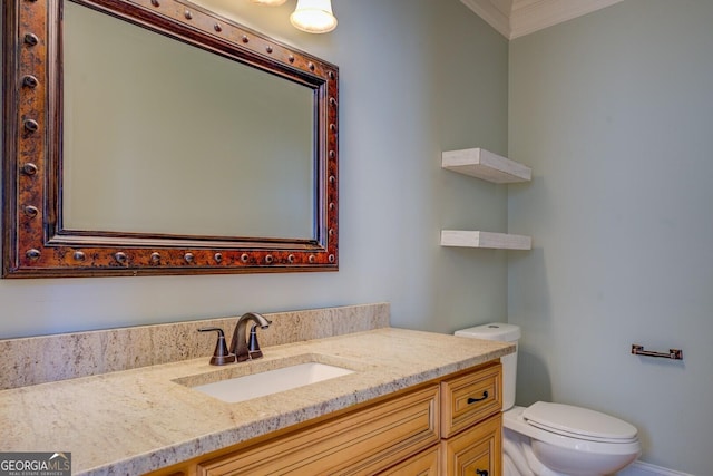 bathroom featuring crown molding, vanity, and toilet