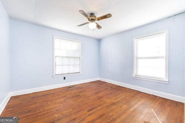 empty room with hardwood / wood-style floors and ceiling fan