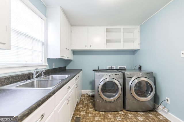 laundry room with separate washer and dryer, sink, and cabinets