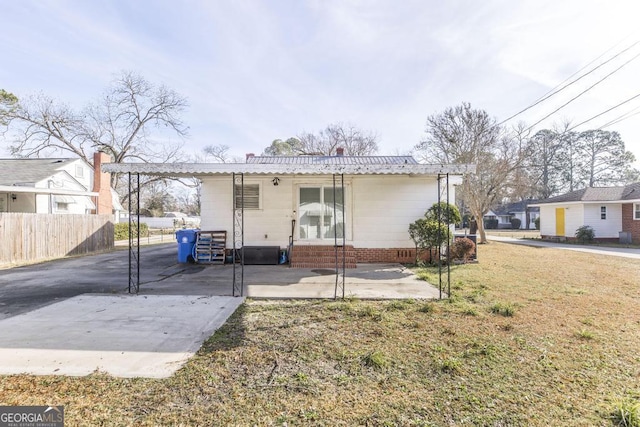 rear view of house with a patio and a yard