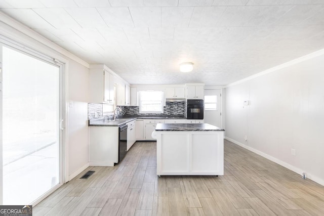 kitchen featuring white cabinetry, crown molding, decorative backsplash, and black appliances