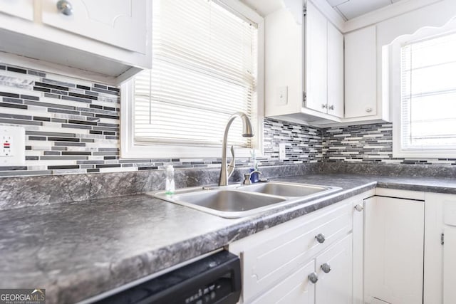 kitchen featuring tasteful backsplash, black dishwasher, sink, and white cabinets