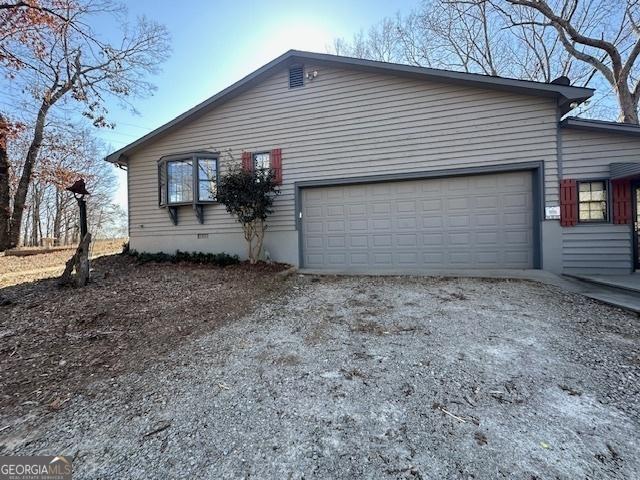 view of home's exterior featuring a garage, driveway, and crawl space