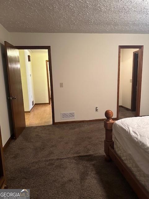 unfurnished bedroom featuring carpet and a textured ceiling