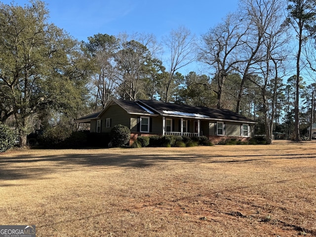 ranch-style home with a porch and a front yard