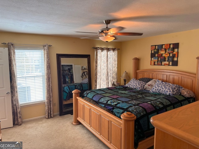 carpeted bedroom with a textured ceiling and ceiling fan