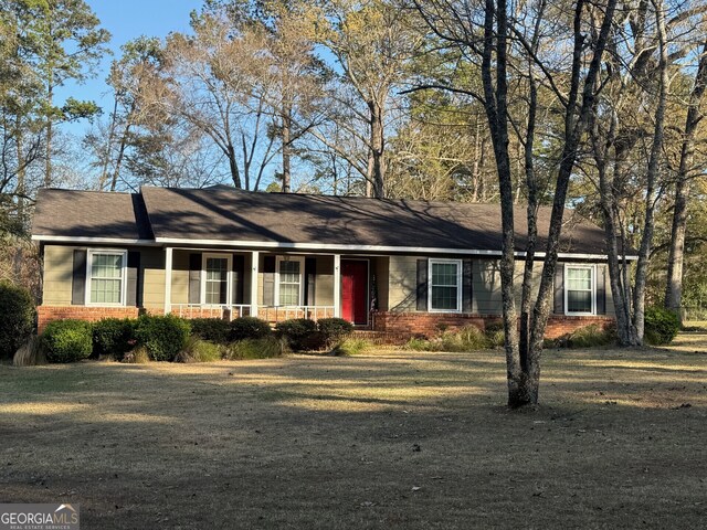 128 Byron Plantation Rd, Albany, GA 31721 - ranch-style house featuring brick siding, covered porch, and a front lawn