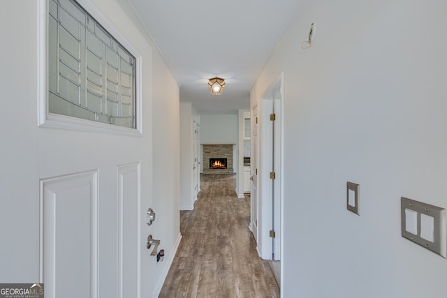 hallway featuring ornamental molding and light hardwood / wood-style floors