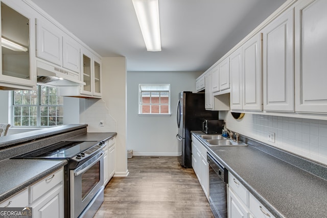 kitchen with plenty of natural light, white cabinets, backsplash, and black appliances