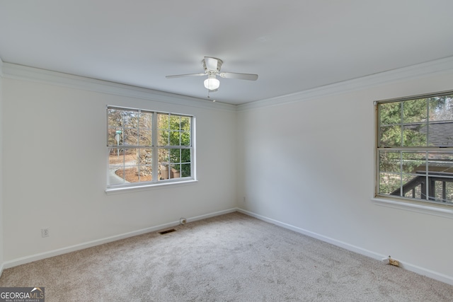 carpeted spare room featuring ceiling fan and ornamental molding