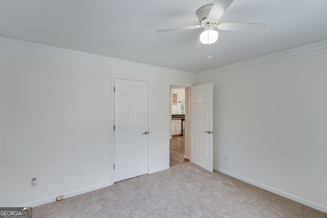 carpeted empty room featuring crown molding and ceiling fan