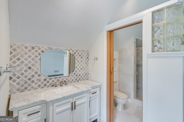 bathroom with tile patterned flooring, vanity, tile walls, and toilet