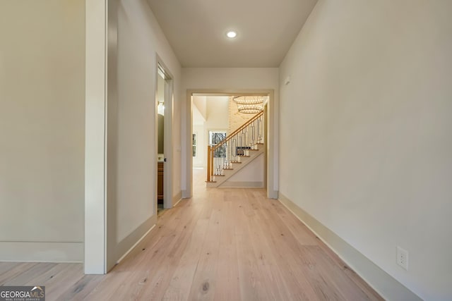 corridor featuring a chandelier and light hardwood / wood-style flooring