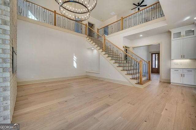 interior space with a high ceiling, a notable chandelier, and light wood-type flooring