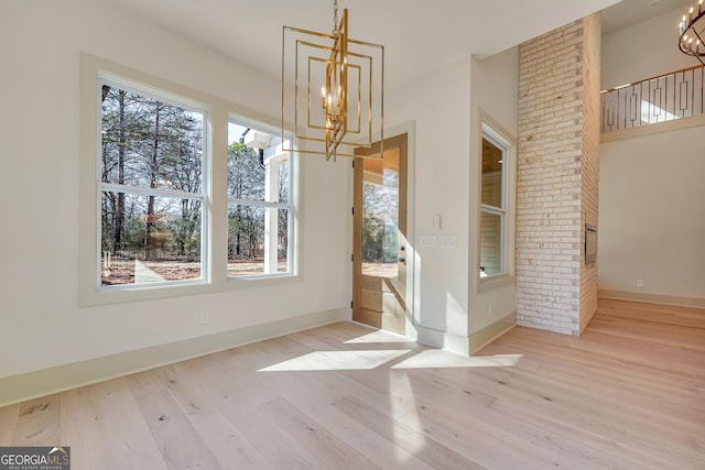 unfurnished dining area with light hardwood / wood-style floors and a chandelier