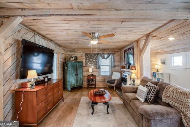 living room with wood ceiling, a fireplace, wooden walls, and light hardwood / wood-style flooring