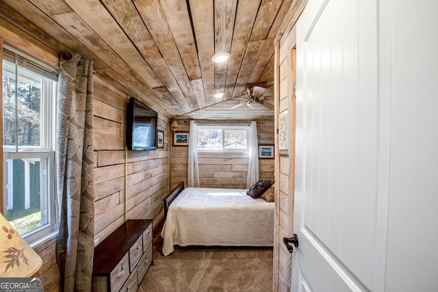 bedroom with multiple windows, lofted ceiling, wooden ceiling, and wooden walls