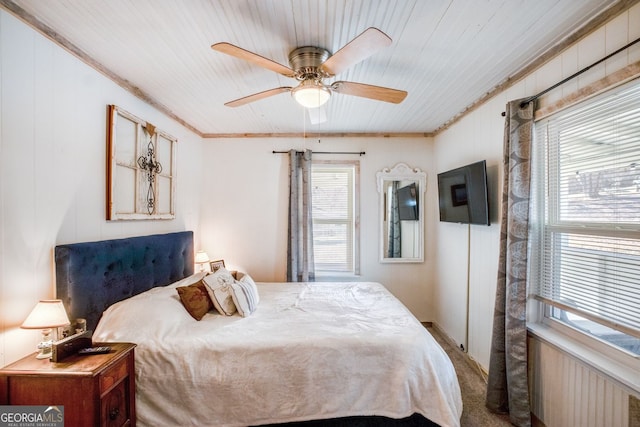 carpeted bedroom featuring ornamental molding and ceiling fan