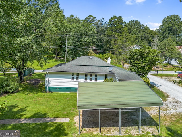 exterior space with a carport and a lawn