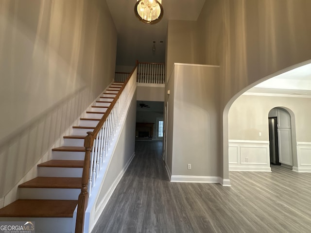 stairway with hardwood / wood-style floors and a high ceiling