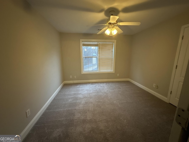 empty room with ceiling fan and dark carpet