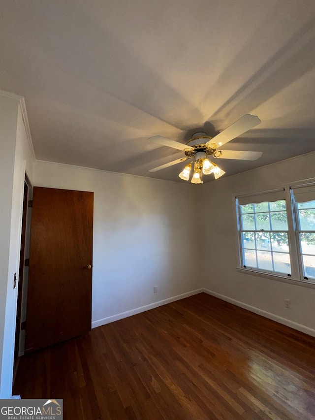 empty room with ceiling fan and dark hardwood / wood-style floors